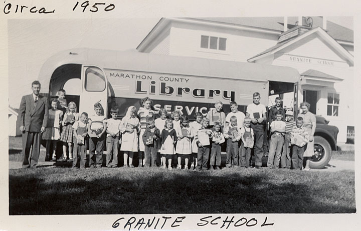 Black and white image of children in front of a bookmobile